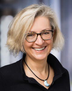 Begeisterte Teilnehmerin der Führungswerkstatt von Robert Jautschus – sie lächelt und zeigt Freude über neue Impulse für Führung und Familienbalance.