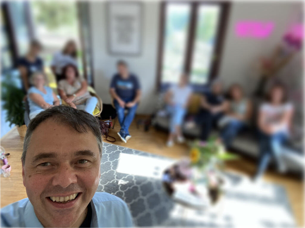 Robert Jautschus steht in einem Workshopraum, im Hintergrund sitzen Teilnehmerinnen und folgen aufmerksam dem Austausch – ein Moment lebendigen Lernens.